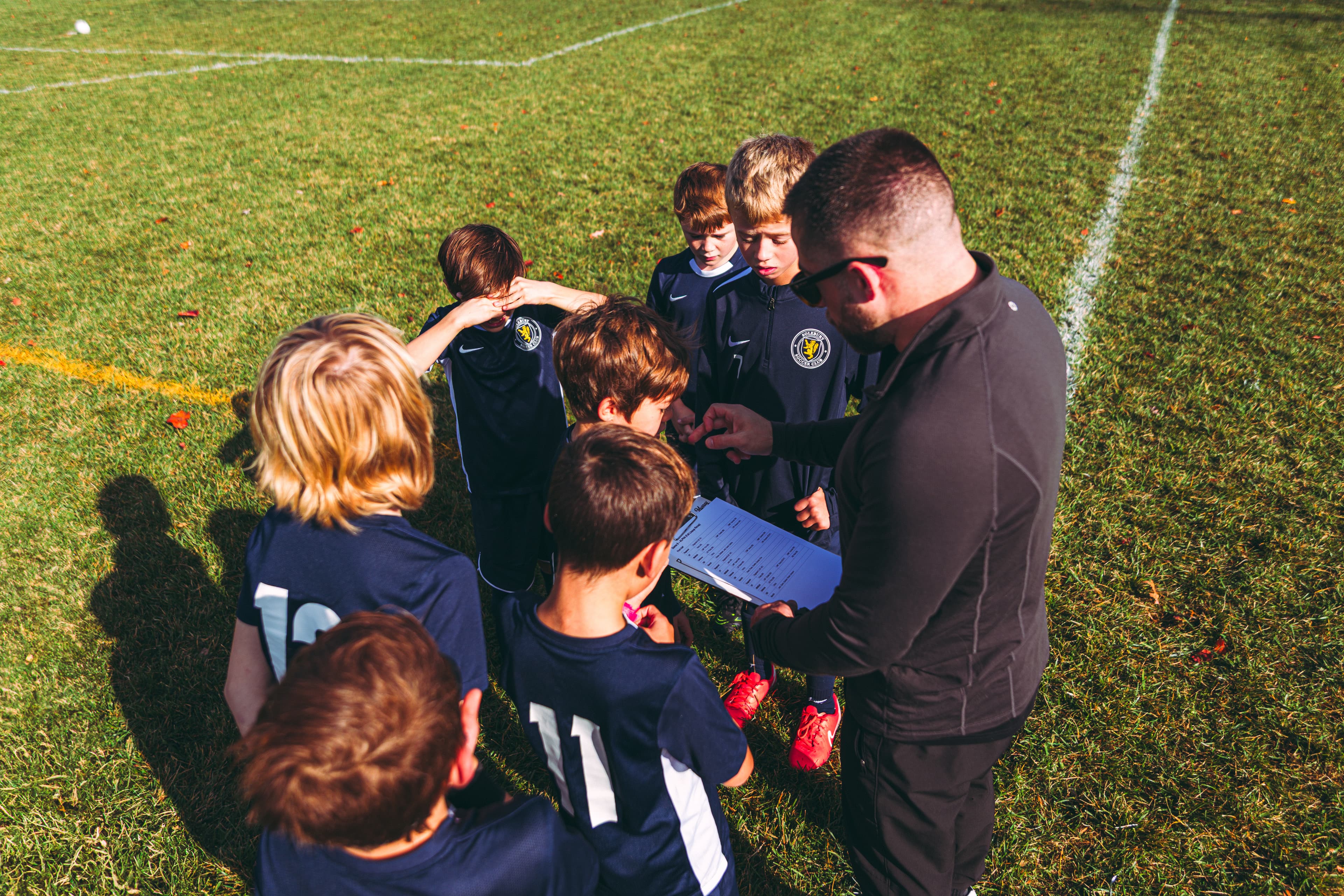 Players gather with their coach on a Solebury Township soccer field in autumn